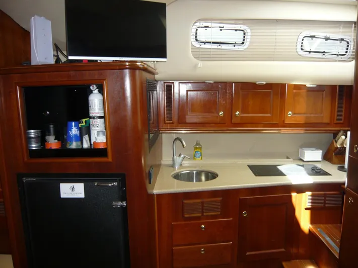 Bobalu Yacht Photos Pics 2004 Rampage 38 Express yacht interior with wooden cabinets, kitchenette, and appliances.