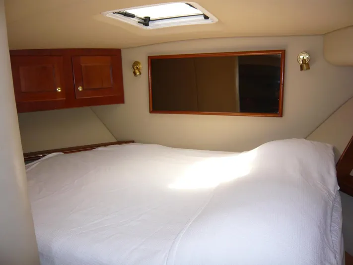 Bobalu Yacht Photos Pics 2004 Rampage 38 Express cabin interior with bed, wooden cabinets, and skylight.