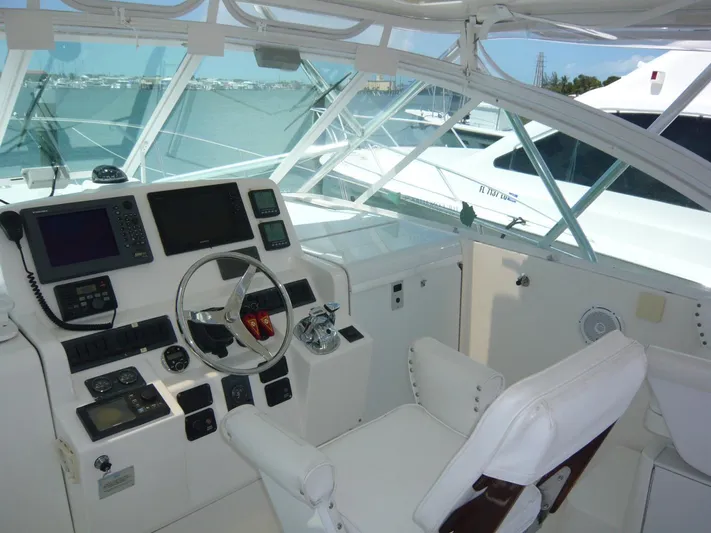 Bobalu Yacht Photos Pics 2004 Rampage 38 Express helm with navigation equipment and white seating.