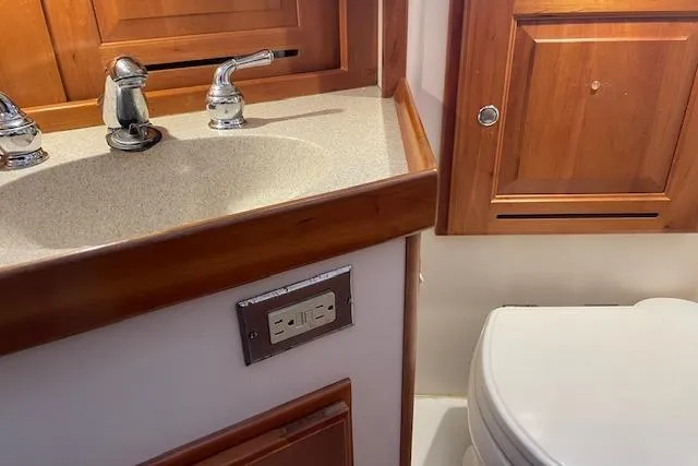 Alegria Yacht Photos Pics Bathroom interior of 2007 Tartan 4400 yacht with wooden cabinetry and sink.