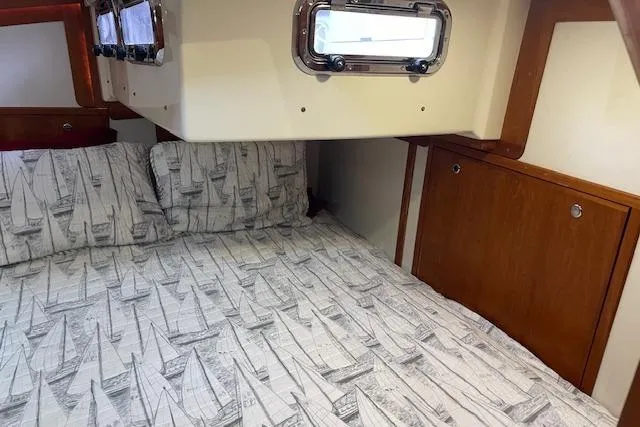 Alegria Yacht Photos Pics Cozy cabin interior of 2007 Tartan 4400 sailboat with nautical-themed bedding.