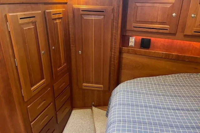 Alegria Yacht Photos Pics Wooden cabin interior of 2007 Tartan 4400 yacht with bed and storage cabinets.