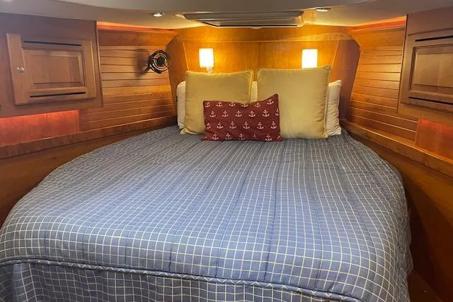 Alegria Yacht Photos Pics Cozy cabin interior of 2007 Tartan 4400 yacht with wooden paneling and comfortable bedding.
