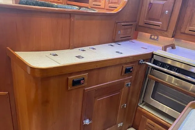 Alegria Yacht Photos Pics Wooden kitchen interior of 2007 Tartan 4400 yacht with stove and cabinets.