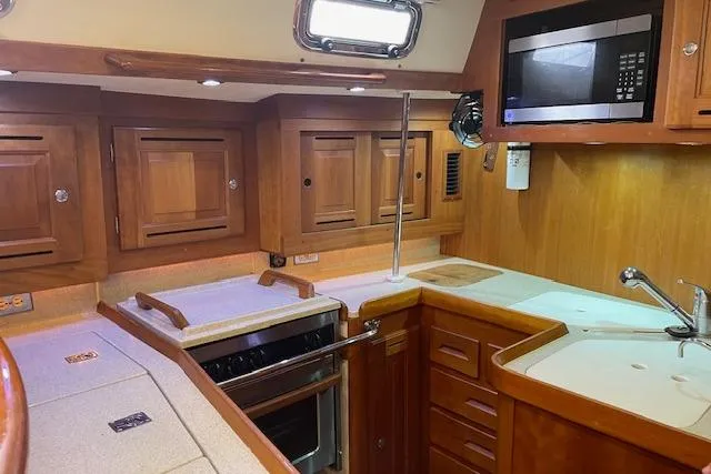 Alegria Yacht Photos Pics Luxurious 2007 Tartan 4400 yacht kitchen with wood cabinetry and modern appliances.