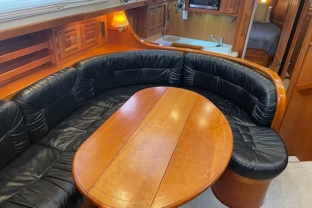 Alegria Yacht Photos Pics Luxurious 2007 Tartan 4400 yacht interior with leather seating and wooden table.