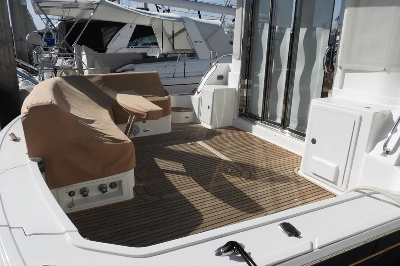  Yacht Photos Pics 2015 Grand Banks 46 Eastbay SX yacht deck with covered seating and wooden flooring.