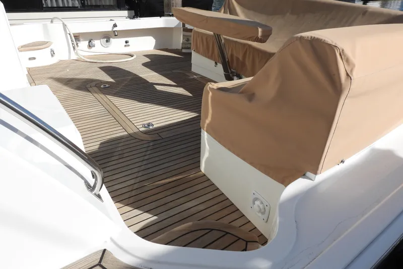  Yacht Photos Pics 2015 Grand Banks 46 Eastbay SX yacht deck with teak flooring and covered seating area.