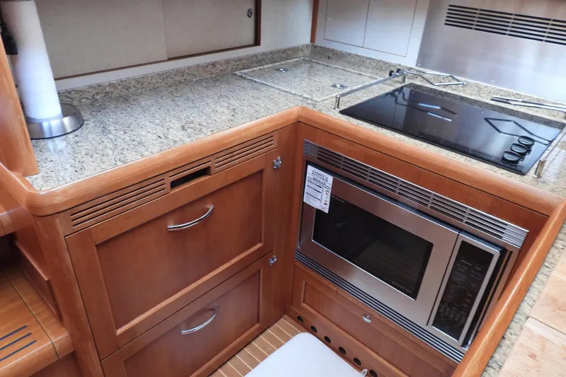  Yacht Photos Pics Galley kitchen in 2015 Grand Banks 46 Eastbay SX with granite countertops and modern appliances.