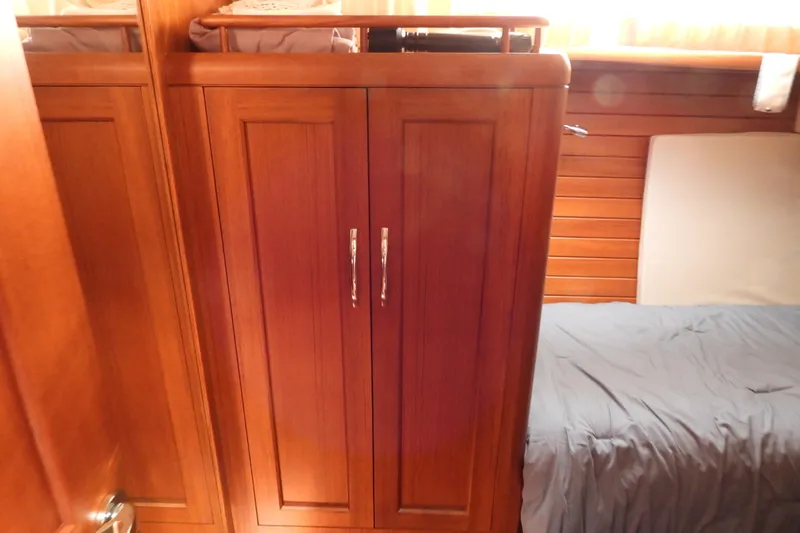  Yacht Photos Pics Wooden cabin interior of 2015 Grand Banks 46 Eastbay SX yacht, featuring a wardrobe and bed.