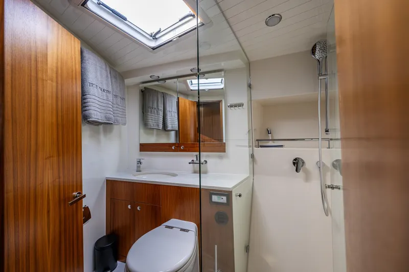 True North Yacht Photos Pics Luxurious bathroom in 2020 Maritimo 59 Motoryacht with wood accents and modern fixtures.