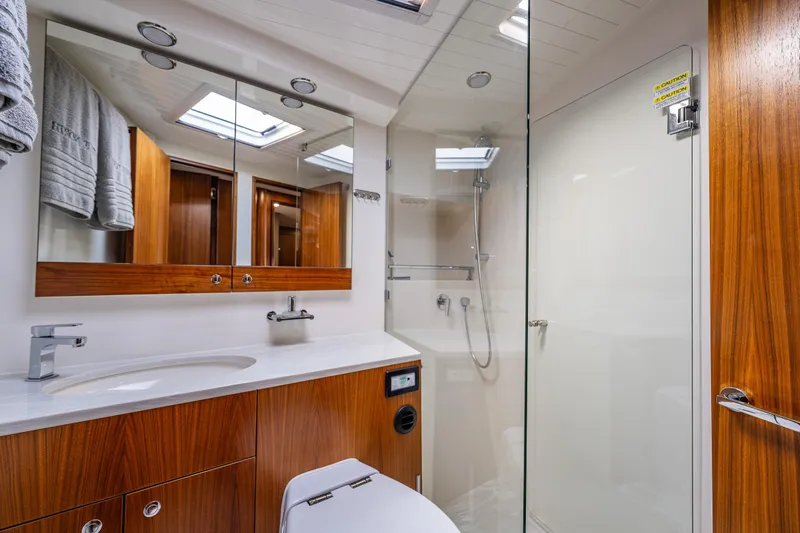 True North Yacht Photos Pics Luxurious bathroom in 2020 Maritimo 59 Motoryacht with wood accents and glass shower.