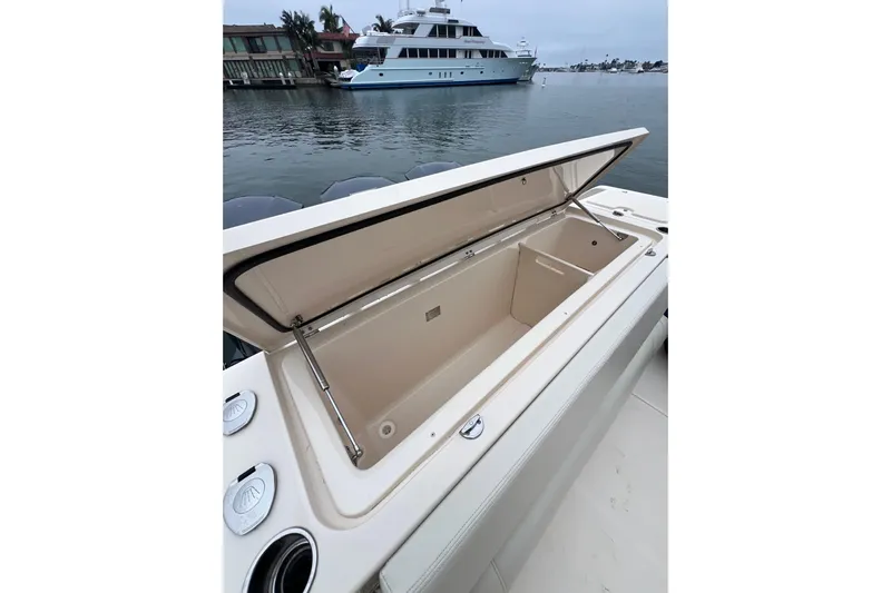 Be Chumming Yacht Photos Pics Open storage compartment on 2018 Grady-White Express 370 boat, docked near luxury yacht.