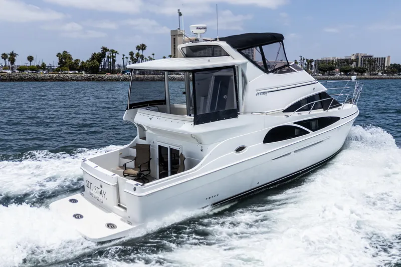  Yacht Photos Pics 2005 Carver 41 Cockpit Motor Yacht cruising on open water, with scenic shoreline background.