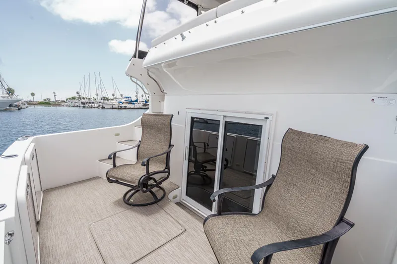  Yacht Photos Pics 2005 Carver 41 Cockpit Motor Yacht with chairs on deck, overlooking marina.