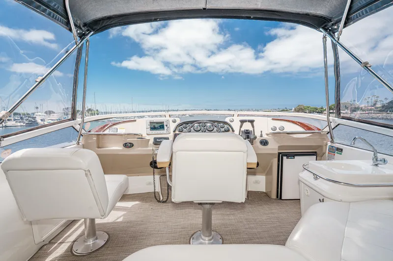  Yacht Photos Pics 2005 Carver 41 Cockpit Motor Yacht helm with ocean view, featuring white seating and navigation controls.