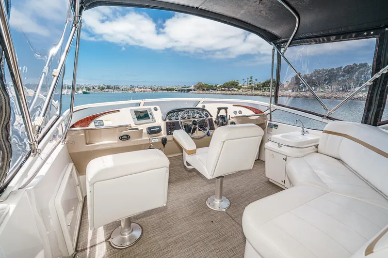  Yacht Photos Pics Interior of 2005 Carver 41 Cockpit Motor Yacht with helm, seating, and scenic water view.