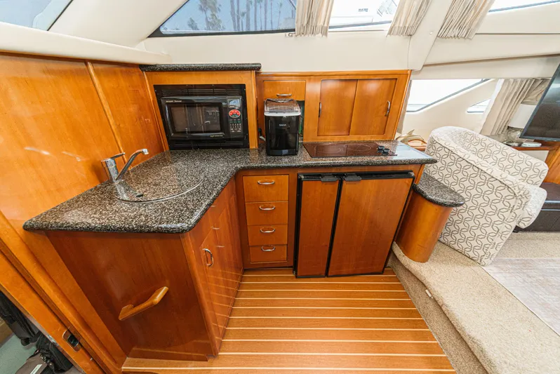  Yacht Photos Pics 2005 Carver 41 Cockpit Motor Yacht kitchen with granite countertops and wooden cabinetry.