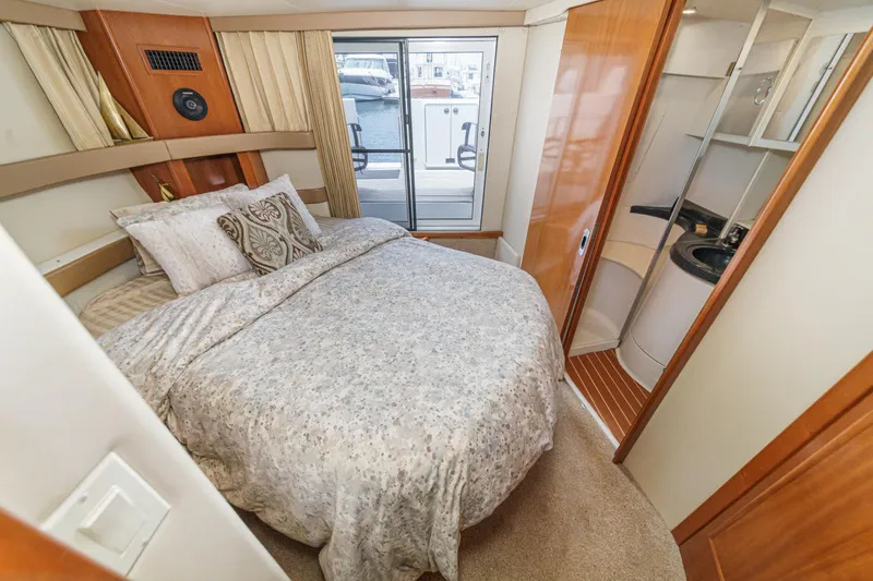  Yacht Photos Pics Luxurious bedroom in 2005 Carver 41 Cockpit Motor Yacht with elegant bedding and ensuite bathroom.