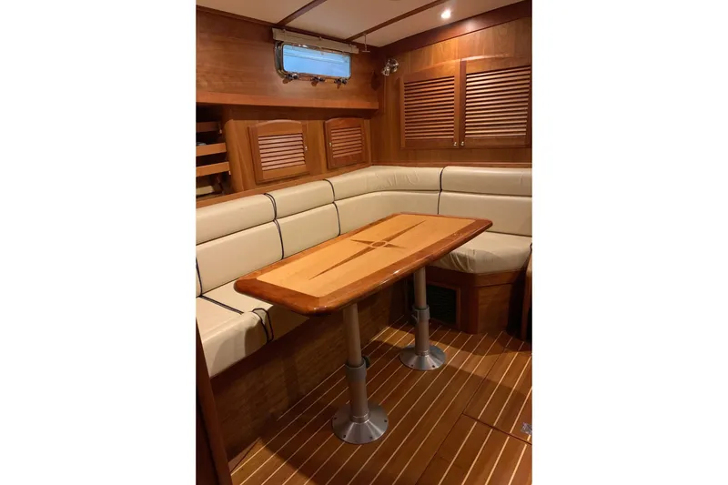 Lionheart Yacht Photos Pics Interior of 2006 Sabre 38 Hard Top Express with wooden table and cushioned seating.