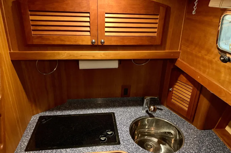 Lionheart Yacht Photos Pics 2006 Sabre 38 Hard Top Express yacht kitchen with wooden cabinets and modern sink.