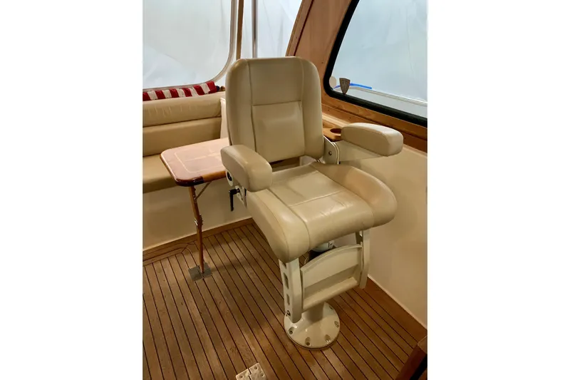 Lionheart Yacht Photos Pics Luxurious captain's chair on 2006 Sabre 38 Hard Top Express yacht, featuring beige leather and wood flooring.