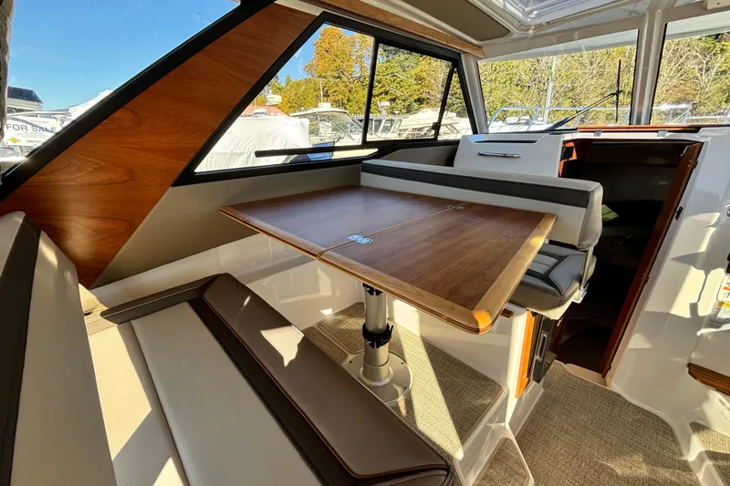  Yacht Photos Pics Interior of 2026 Cutwater C-288 Coupe featuring a wooden table and seating area.