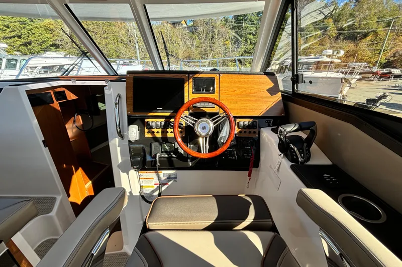  Yacht Photos Pics 2026 Cutwater C-288 Coupe helm with modern controls and wooden steering wheel.