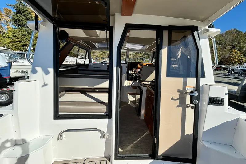  Yacht Photos Pics 2026 Cutwater C-288 Coupe interior view with open door, showcasing seating and helm.
