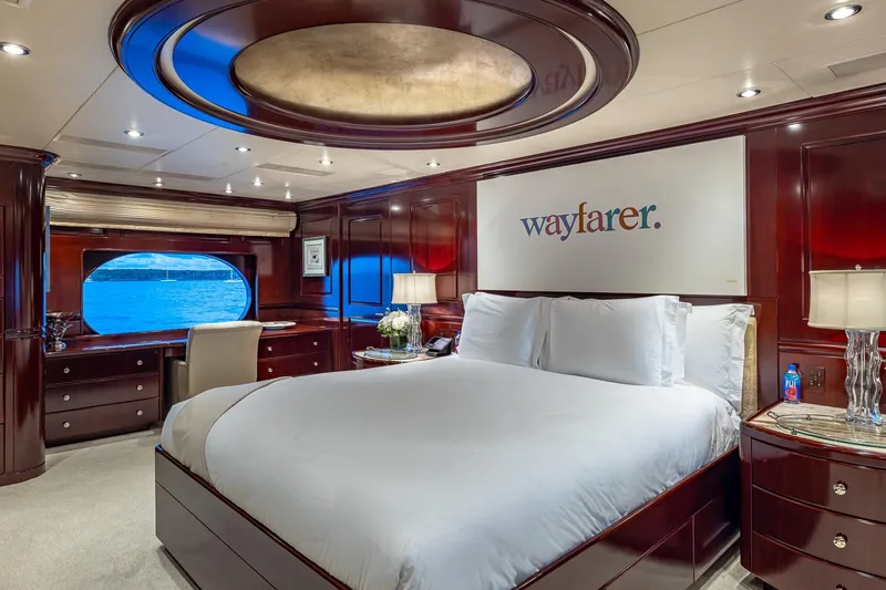 Lady Joy Yacht Photos Pics Luxurious bedroom on 2007 Christensen Tri-Deck yacht with elegant wood paneling and ocean view.