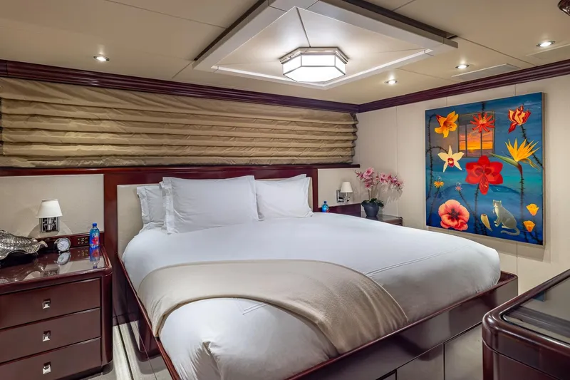 Lady Joy Yacht Photos Pics Luxurious bedroom on 2007 Christensen Tri-Deck yacht with elegant decor and vibrant floral artwork.