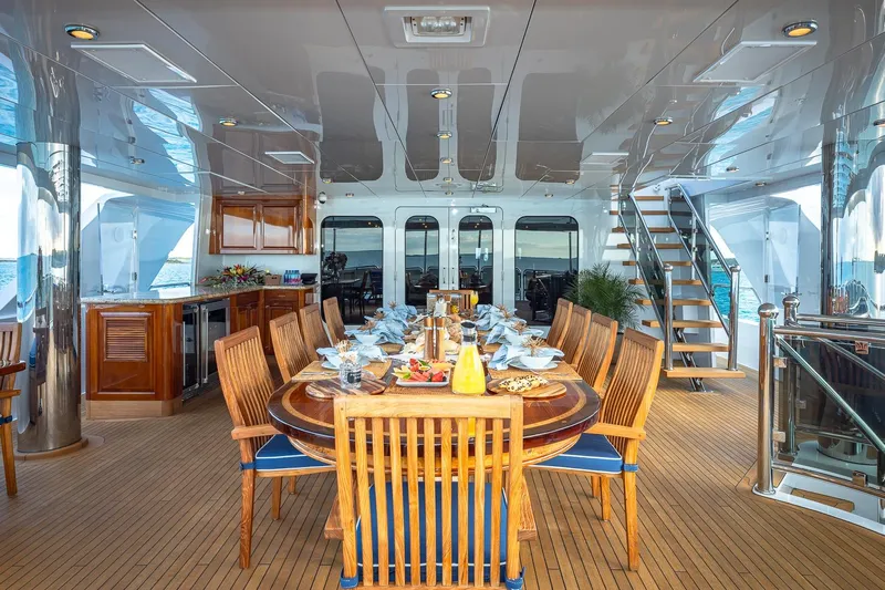 Lady Joy Yacht Photos Pics Luxurious dining area on 2007 Christensen Tri-Deck yacht with elegant wooden furniture.