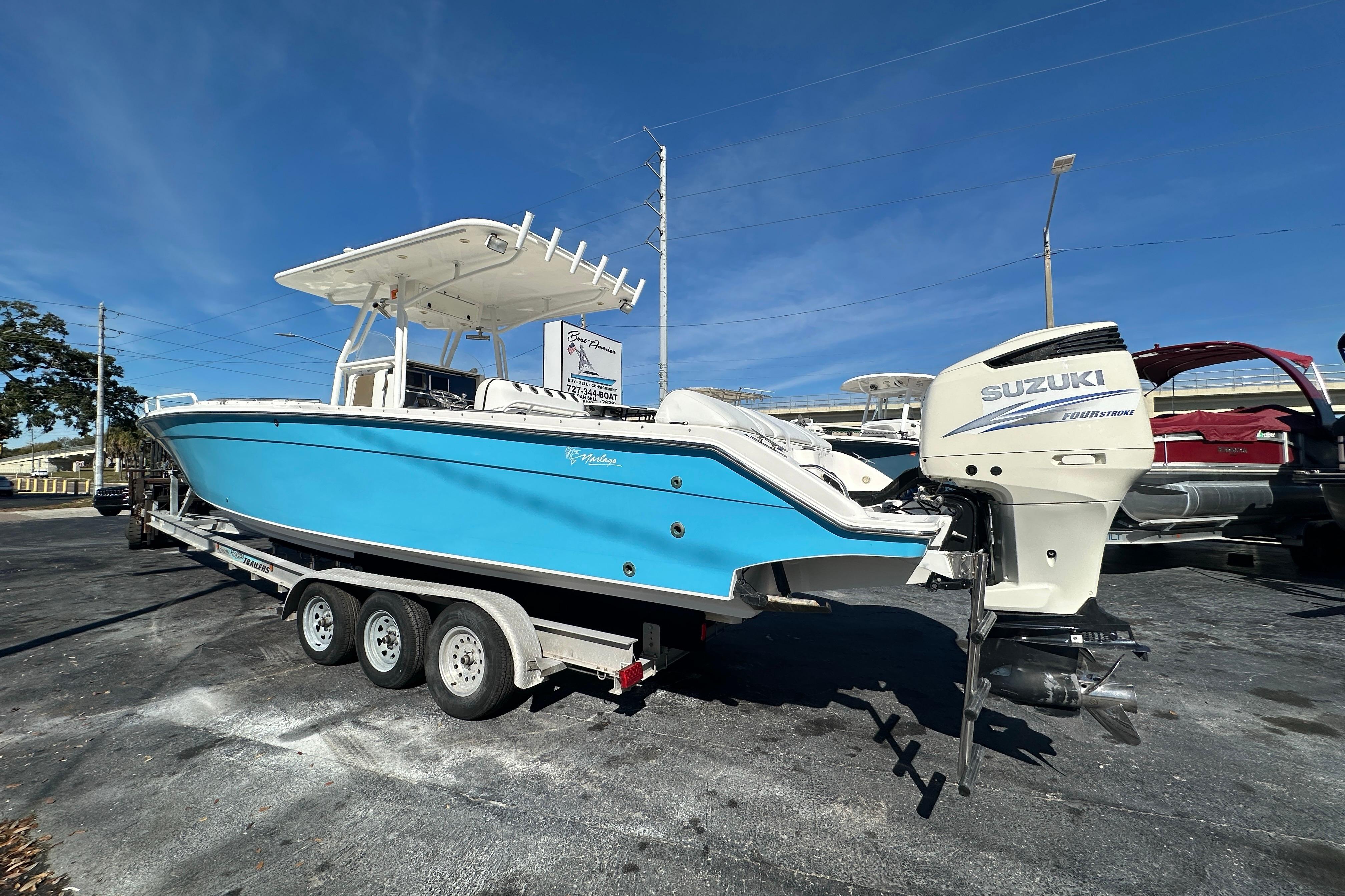2004 Marlago 35 FS boat with Suzuki engine on trailer under clear blue sky.