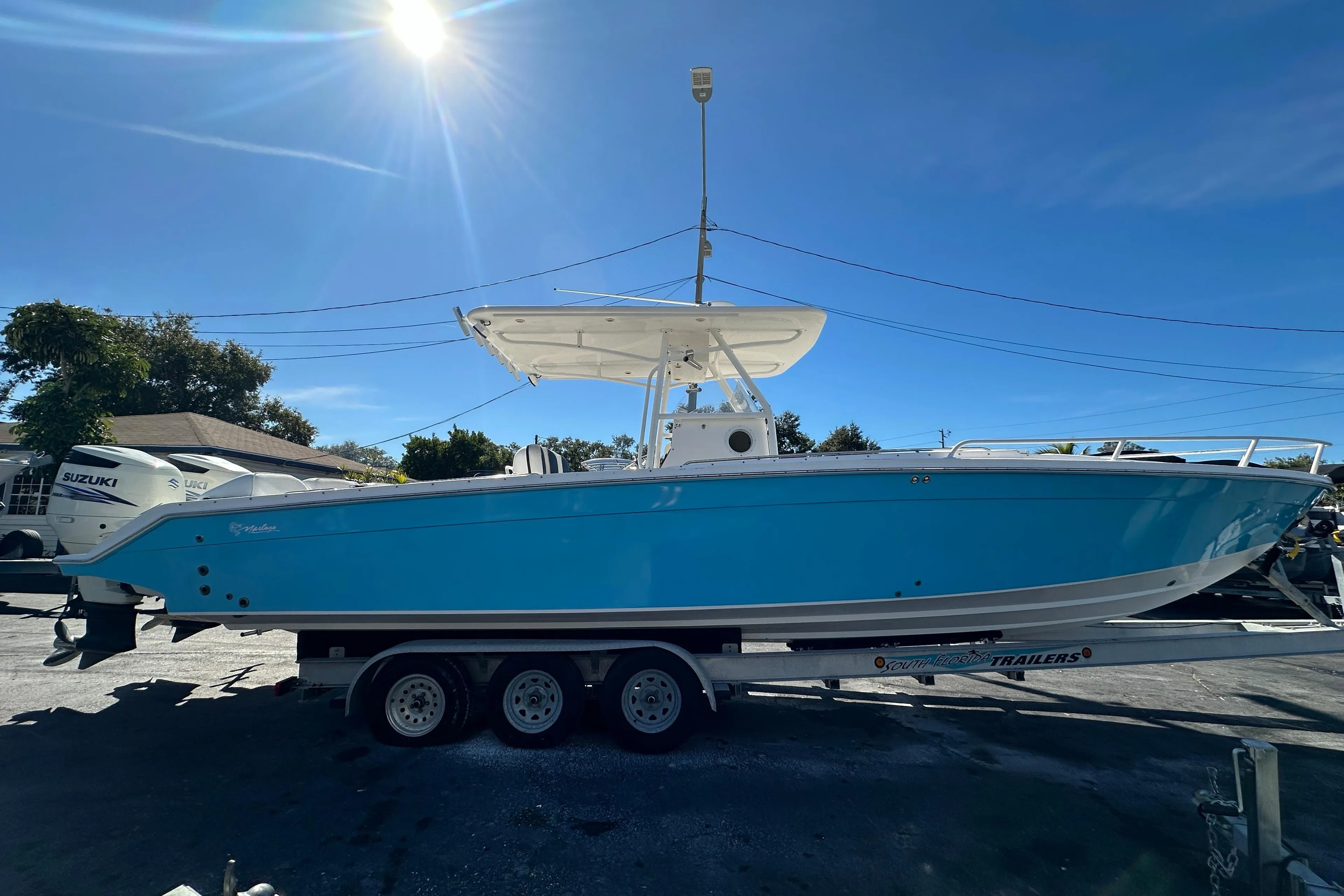 2004 Marlago 35 FS boat on trailer under bright sunlit sky.