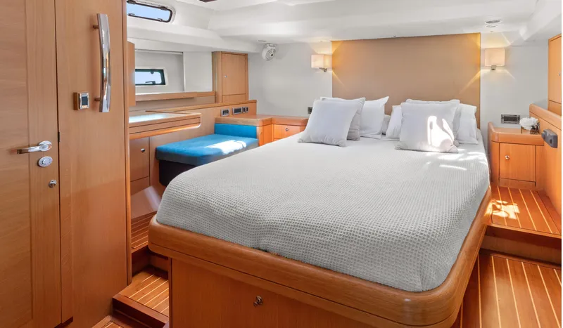 Margot Yacht Photos Pics Luxurious interior of 2013 Oyster 575 yacht with elegant wood finish and cozy bedding.
