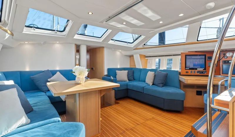 Margot Yacht Photos Pics Luxurious interior of 2013 Oyster 575 yacht with blue seating and wooden flooring.