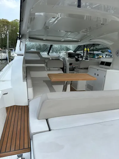 Small Batch Yacht Photos Pics 2016 Jeanneau Leader 36 yacht interior with seating and wooden table.