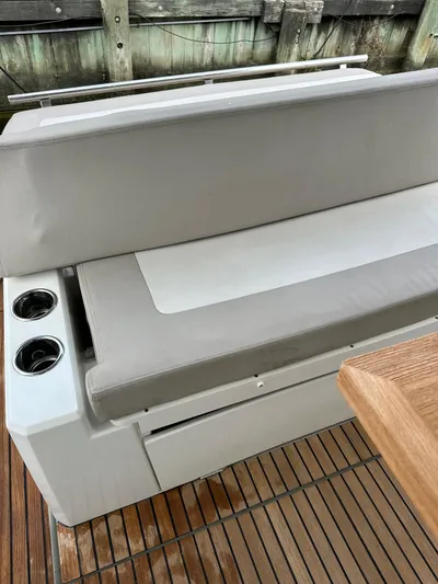 Small Batch Yacht Photos Pics 2016 Jeanneau Leader 36 boat seating area with cup holders and wooden deck.