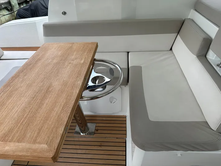 Small Batch Yacht Photos Pics Jeanneau Leader 36 2016 boat interior with wooden table and cushioned seating.