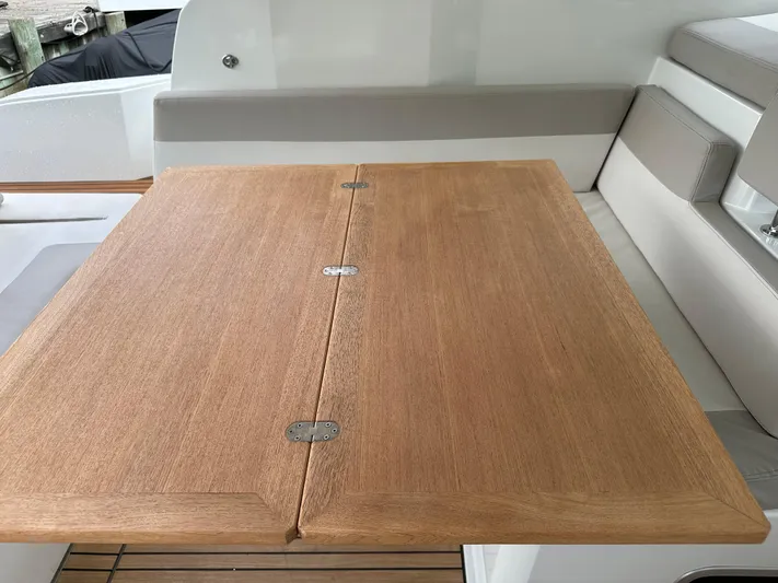 Small Batch Yacht Photos Pics Wooden table on the deck of a 2016 Jeanneau Leader 36 boat.