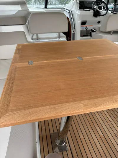 Small Batch Yacht Photos Pics Interior of 2016 Jeanneau Leader 36 with wooden table and seating area.