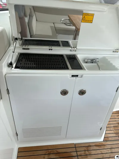 Small Batch Yacht Photos Pics Outdoor kitchenette on a 2016 Jeanneau Leader 36 yacht with grill and sink.
