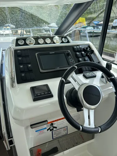 Small Batch Yacht Photos Pics 2016 Jeanneau Leader 36 helm station with steering wheel and navigation controls.