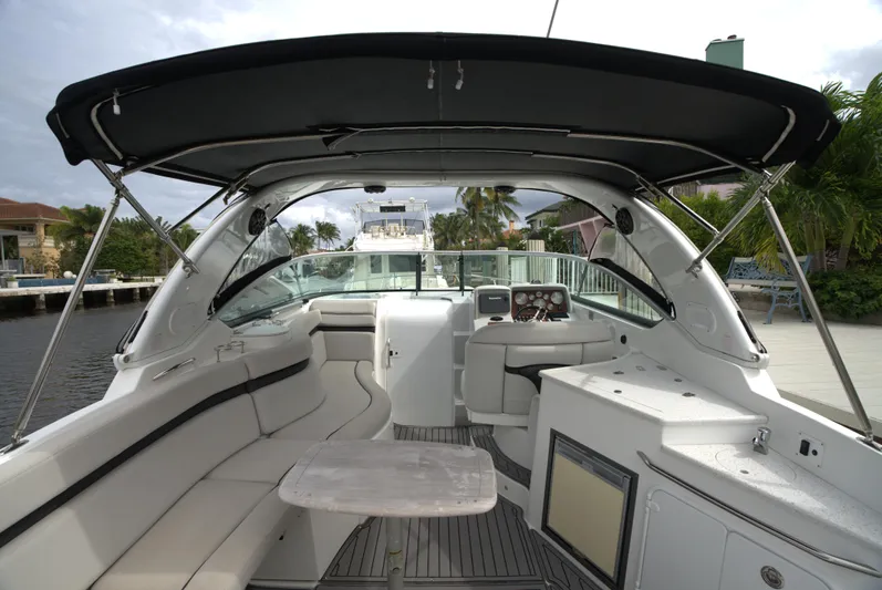  Yacht Photos Pics 2017 Rinker 320 Express Cruiser interior with seating, table, and helm under canopy.