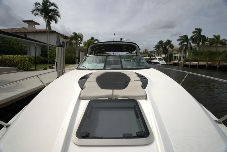  Yacht Photos Pics 2017 Rinker 320 Express Cruiser docked by palm trees and waterfront homes.