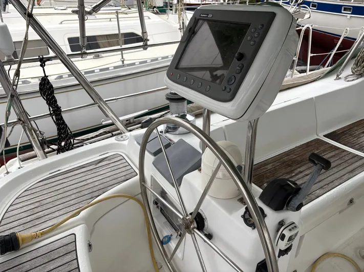 At Last Yacht Photos Pics Steering wheel and navigation system on 2004 Beneteau Oceanis 473 sailboat.