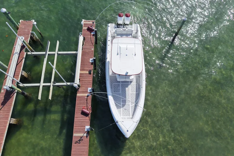  Yacht Photos Pics Aerial view of a 2015 Deep Impact 33 boat docked in clear green water.