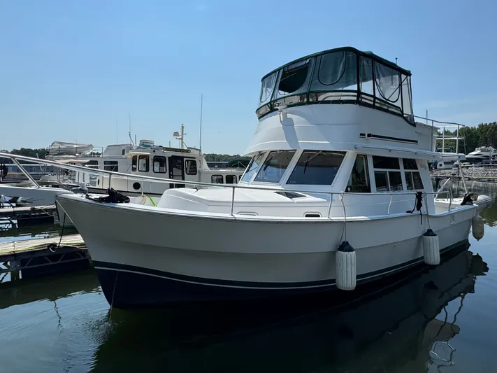 Eirene Yacht Photos Pics 2001 Mainship 390 yacht docked at marina, featuring spacious upper deck and classic design.