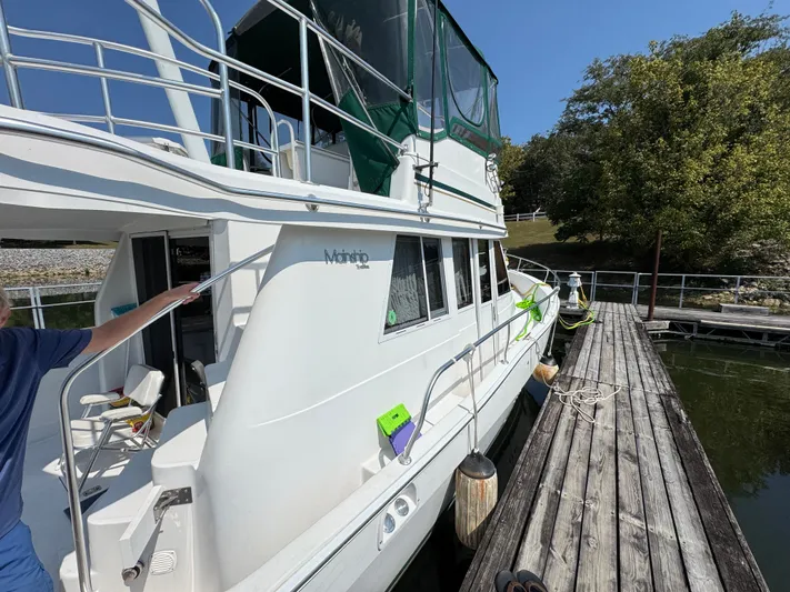 Eirene Yacht Photos Pics 2001 Mainship 390 yacht docked, featuring white exterior and green canopy.