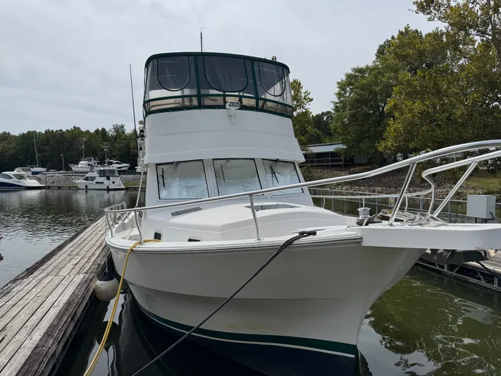 Eirene Yacht Photos Pics 2001 Mainship 390 yacht docked at a marina, surrounded by trees and other boats.